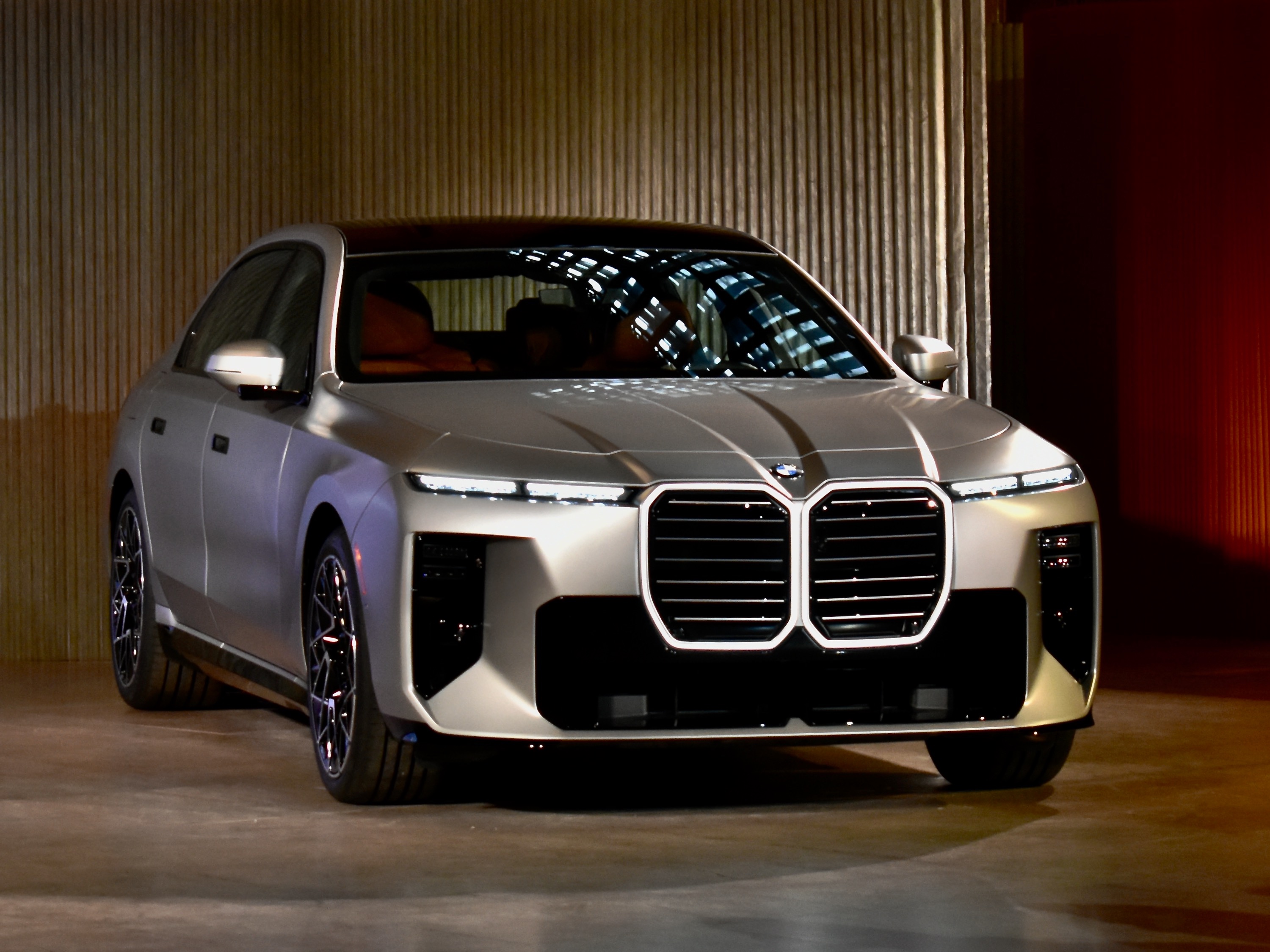 Серебристый BMW 7 серии в интерьере с золотистой стеной